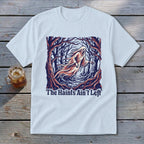 White t-shirt with a graphic of a ghost in a dark forest and text "The Haints Ain't Left".
