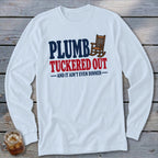 White long sleeve shirt with text "PLUMBER TUCKED OUT AND IT AIN'T EVEN DINNER" and rocking chair.