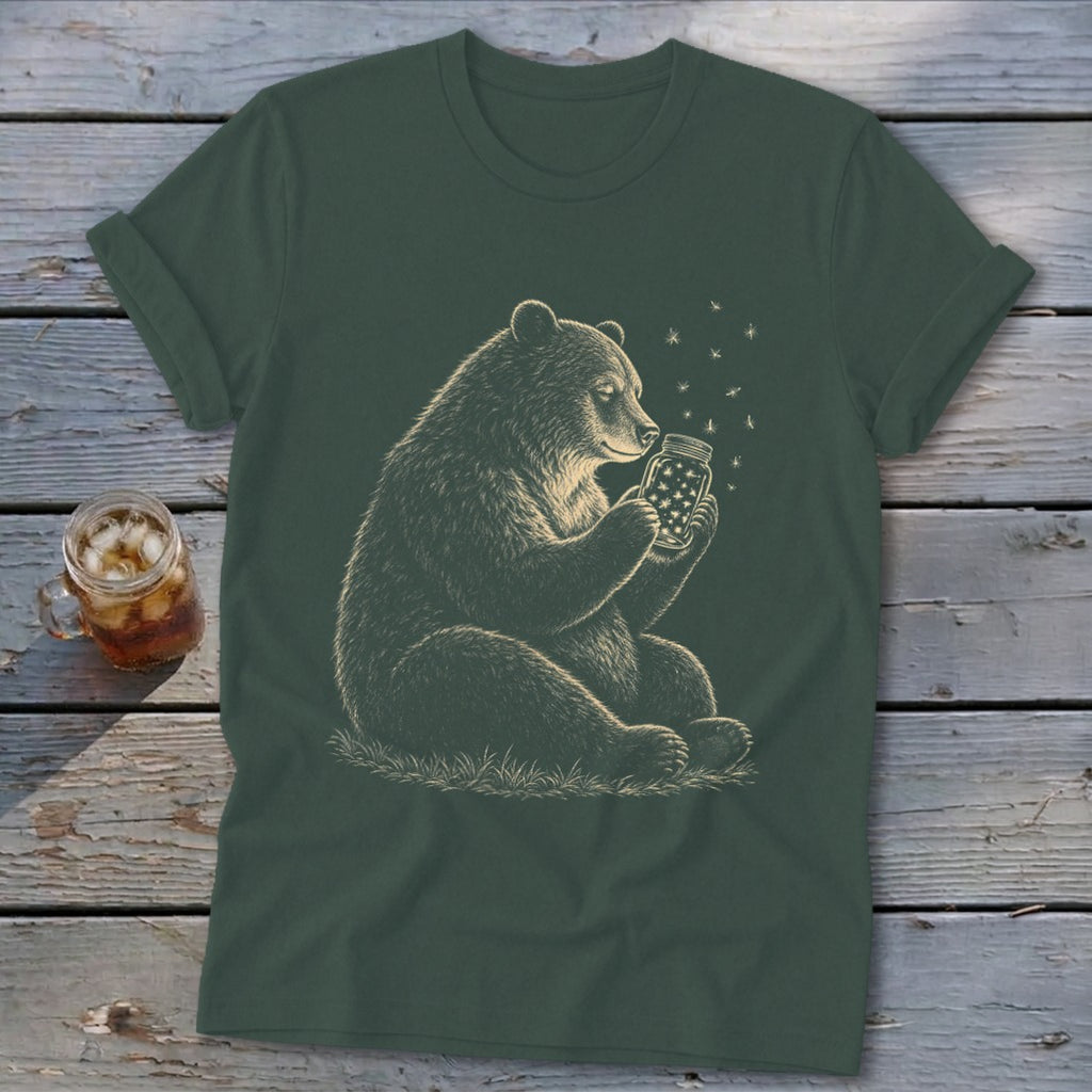 Bear holding a mason jar filled with stars and fireflies on a dark green t-shirt.