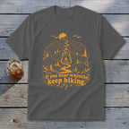 Dark gray t-shirt with orange mountain, lantern, and "If you hear whistlin', keep hiking" text graphic.