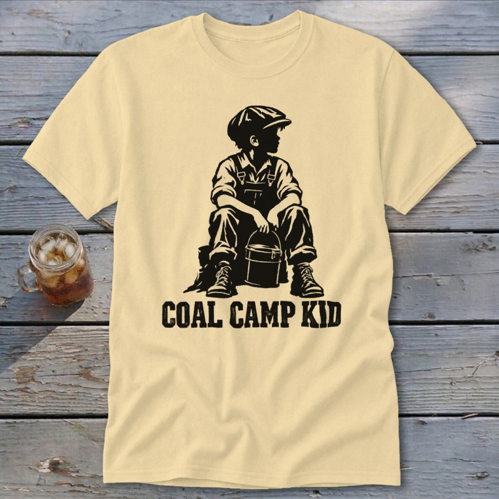 Pale yellow t-shirt with black graphic of a boy in overalls holding a bucket, text "COAL CAMP KID".