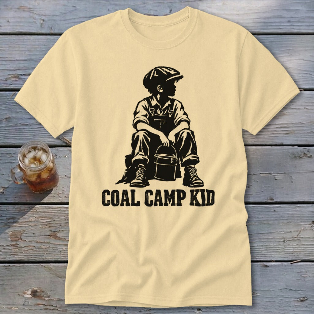 Pale yellow t-shirt with black graphic of a boy in overalls holding a bucket, text "COAL CAMP KID".