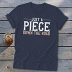 Navy t-shirt with text "Just a Piece Down the Road" and glass of iced tea.