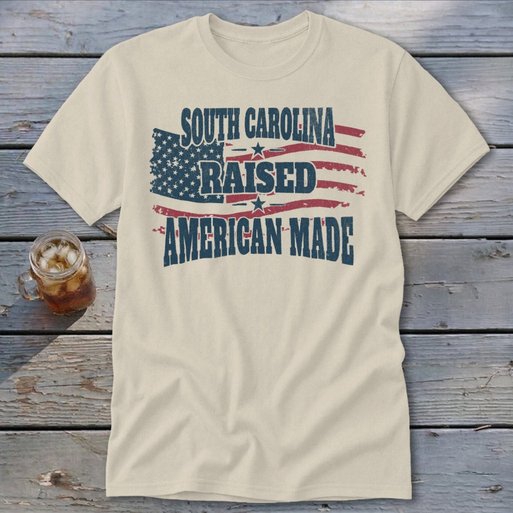 Cream t-shirt with distressed American flag and text "South Carolina Raised American Made".