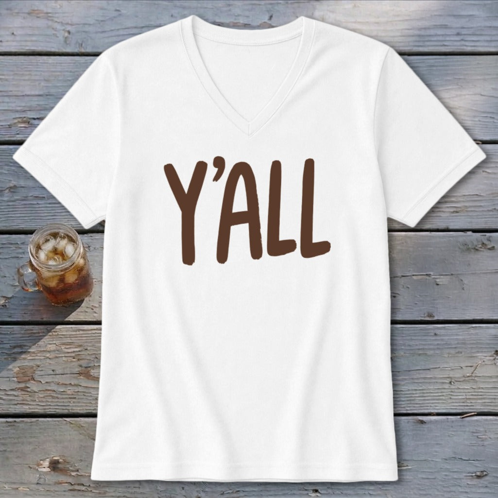 White V-neck t-shirt with brown "Y'ALL" graphic on wooden surface.