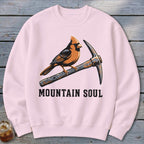 Pink crewneck sweatshirt with a cardinal perched on a pickaxe above the text "MOUNTAIN SOUL".