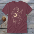 Maroon t-shirt with a bear sitting on a stool playing a banjo.