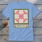 Light blue t-shirt featuring a quilt block design and "SHOO FLY" text.