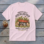 Pink t-shirt with a speckled pup sleeping under a red wagon, with text.