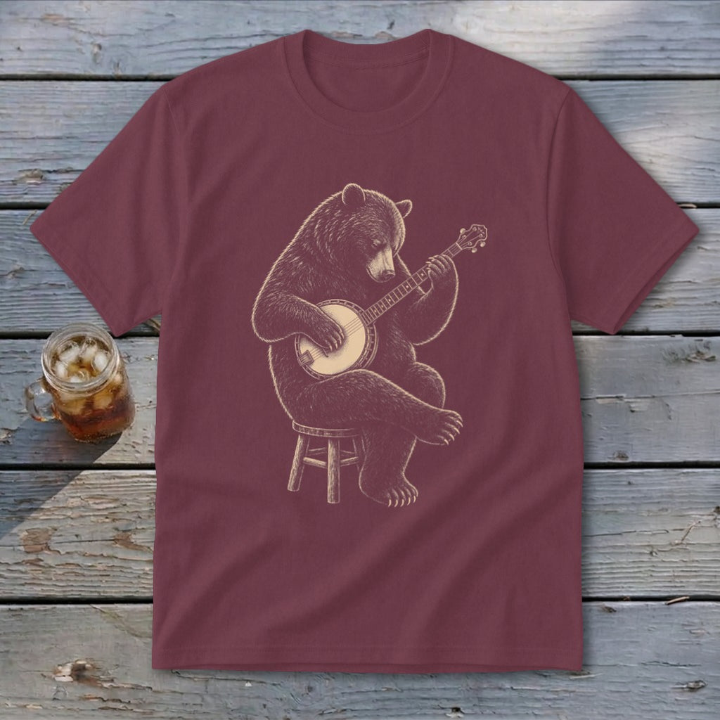 Bear playing banjo seated on stool graphic on maroon t-shirt.