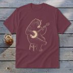 Bear playing banjo seated on stool graphic on maroon t-shirt.