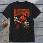 A black t-shirt features a graphic of a red cardinal perched on a snow-covered pine branch with the text "REDBIRD" above it.