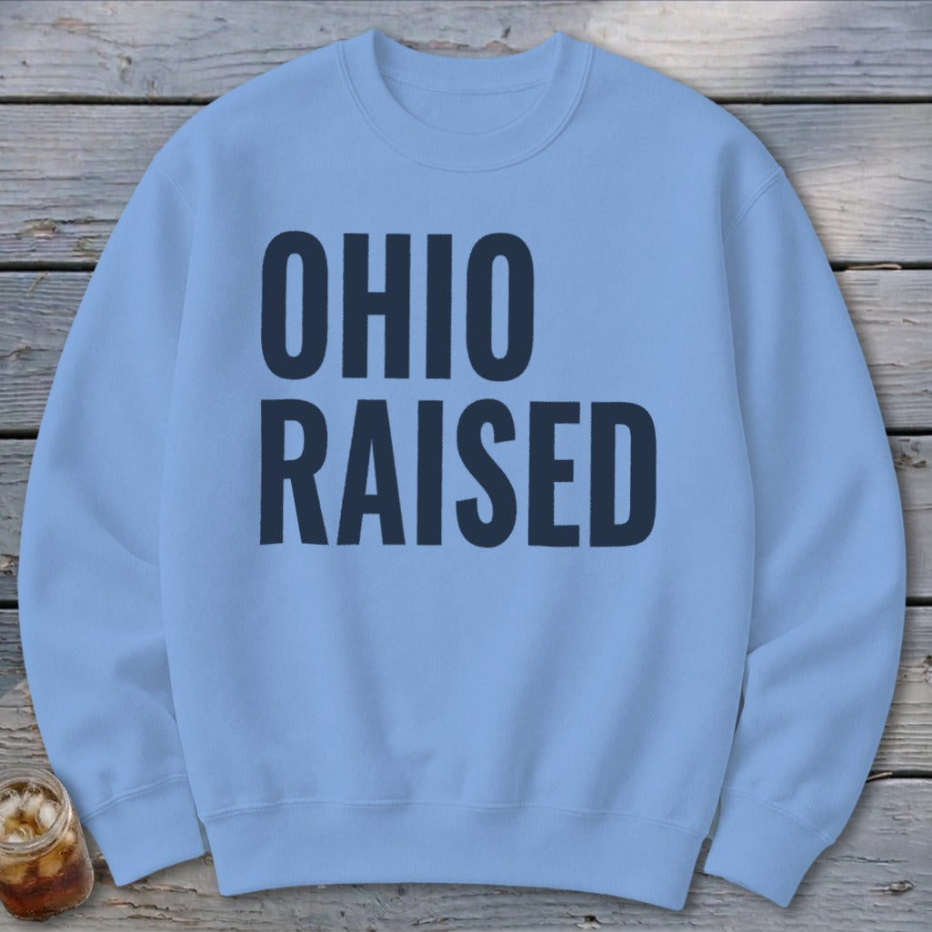 Light blue crewneck sweatshirt with "OHIO RAISED" in dark blue block letters.