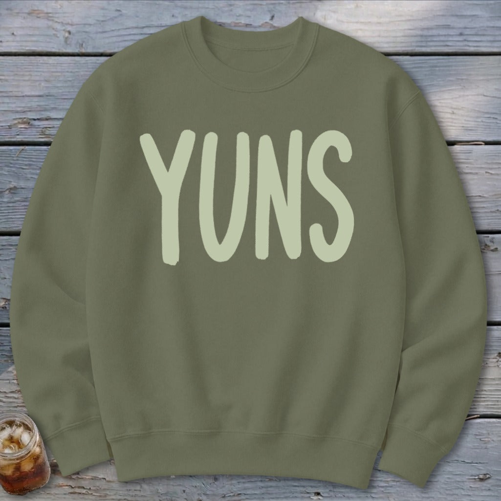 Olive green sweatshirt with "YUNS" text in a light green brush stroke font.