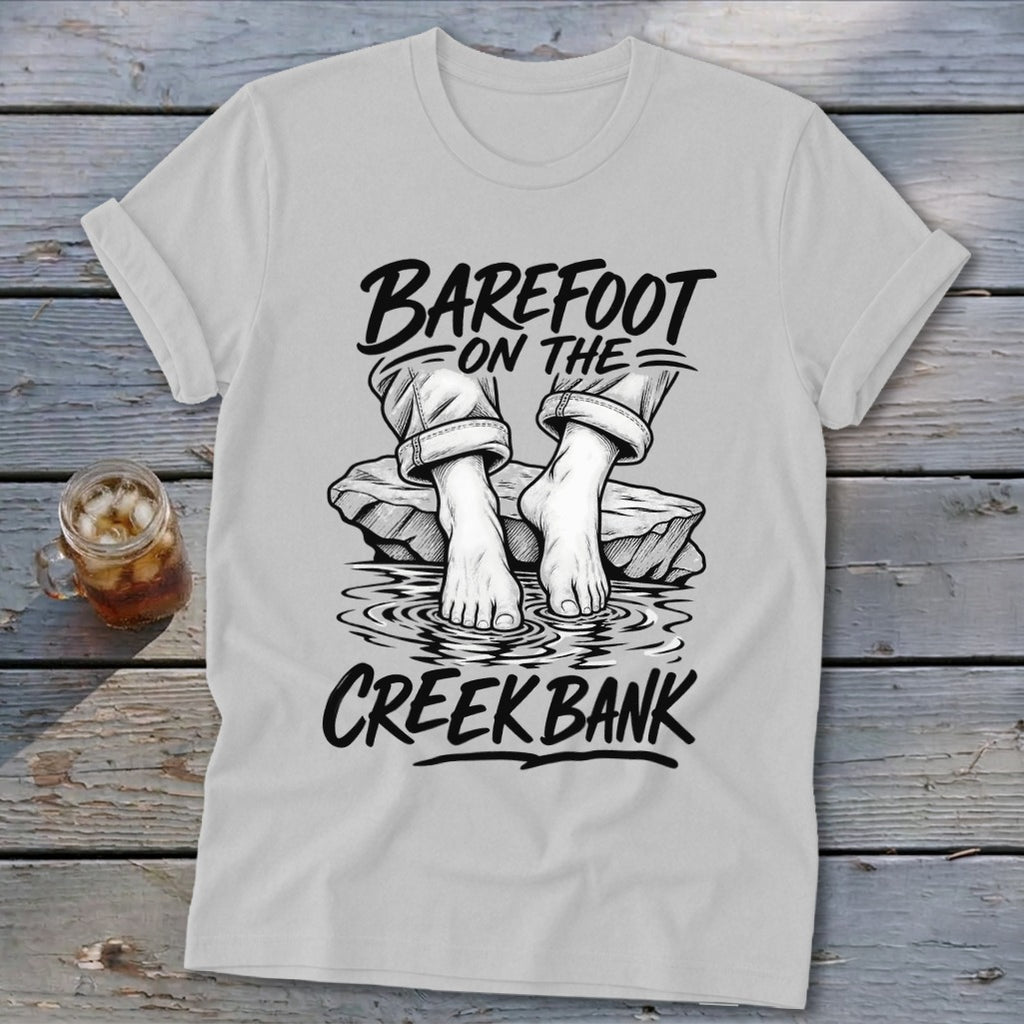 T-shirt with "Barefoot on the Creek Bank" text and graphic of bare feet on rocks in water.
