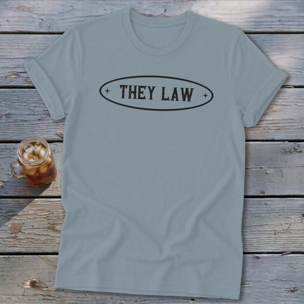 Light blue t-shirt with "THEY LAW" text in an oval emblem.