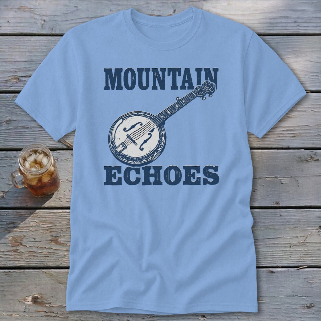 Light blue t-shirt featuring the text Mountain Echoes and a banjo graphic on a wooden table.