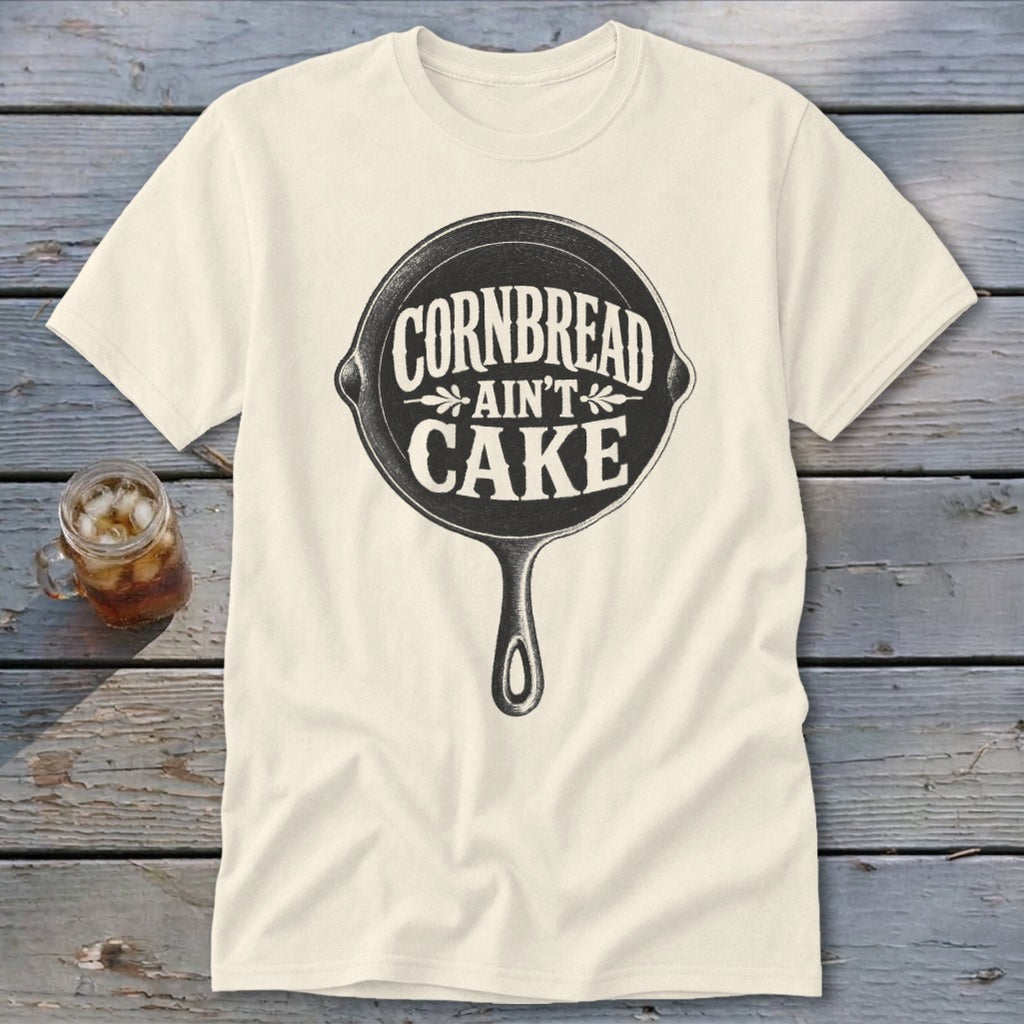 Cream t-shirt with cast iron skillet graphic saying "Cornbread Ain't Cake".