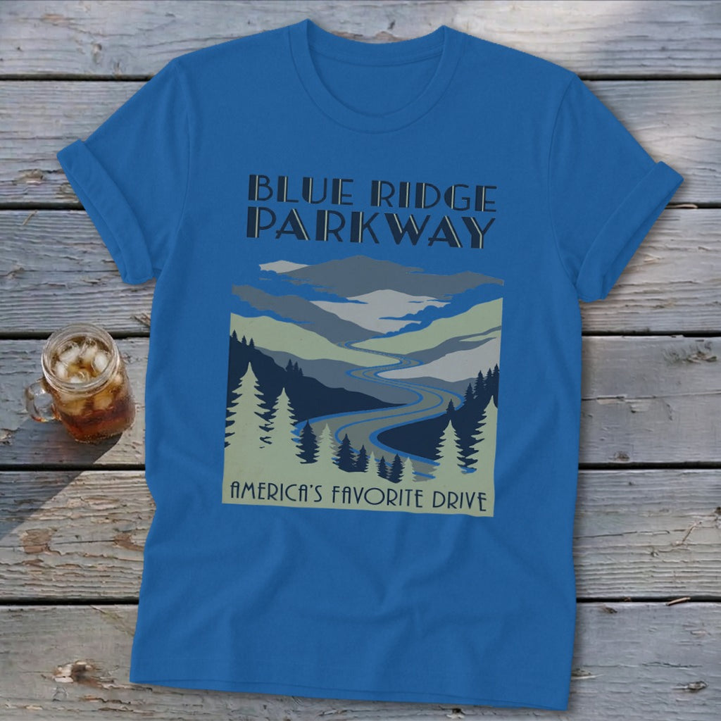 Blue t-shirt featuring a stylized landscape graphic of mountains, trees, and a winding road.