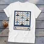White t-shirt with "Flying Geese" text and a blue and gray patchwork quilt design.