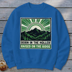 Blue crewneck sweatshirt with a graphic of mountains and text reading Born in the Holler Raised on the Ridge.