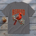 A dark gray crewneck t-shirt featuring a graphic of a red cardinal perched on a snowy branch with red berries and the text Redbird arched above.