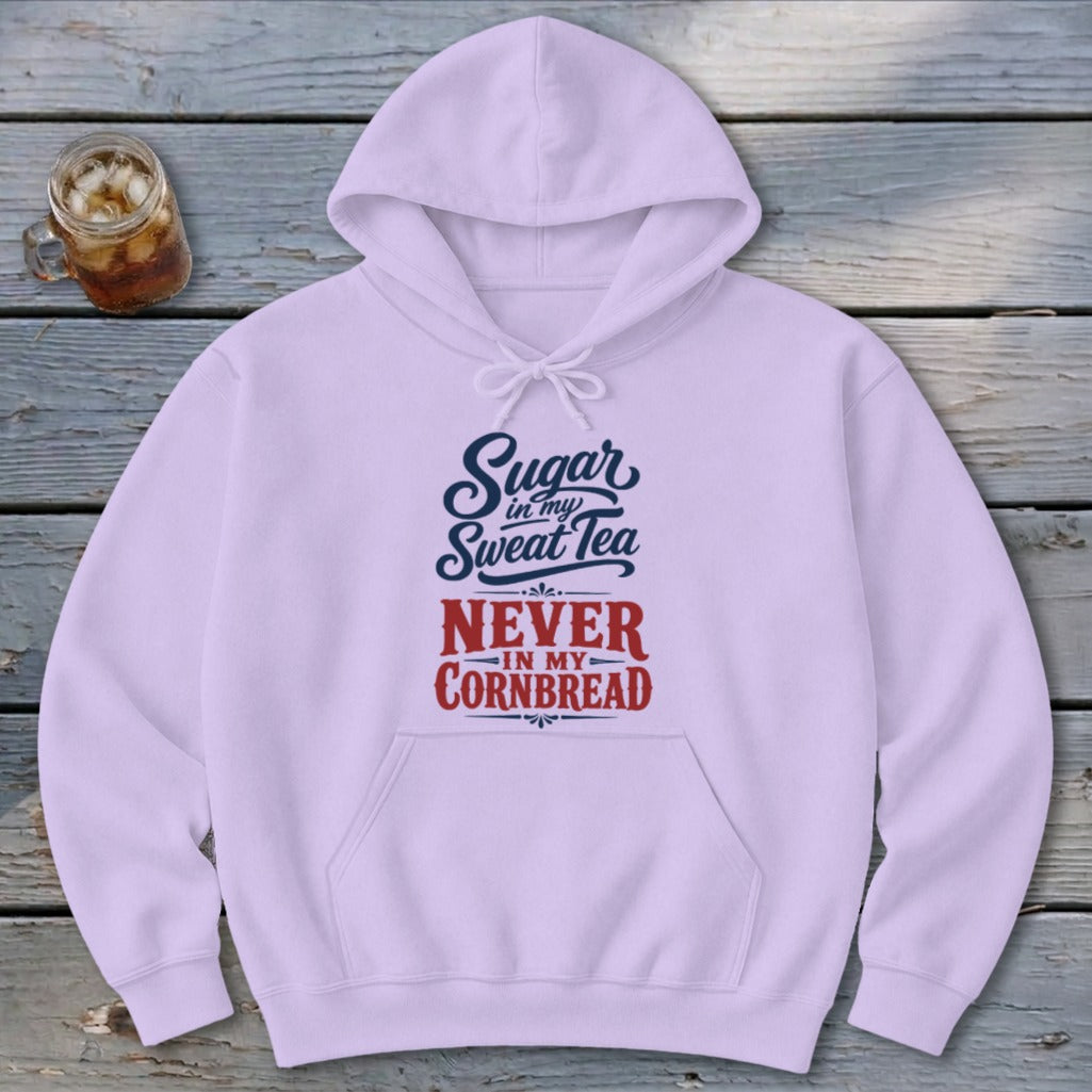 A light purple hoodie featuring the text Sugar in my Sweet Tea, Never in my Cornbread on a rustic wooden table.