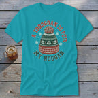 A teal t-shirt featuring a graphic of a winter hat with text reading A toboggan is for my noggan.