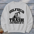 White sweatshirt with black text and oil rig graphic: "OILFIELD TRASH AND PROUD OF IT."