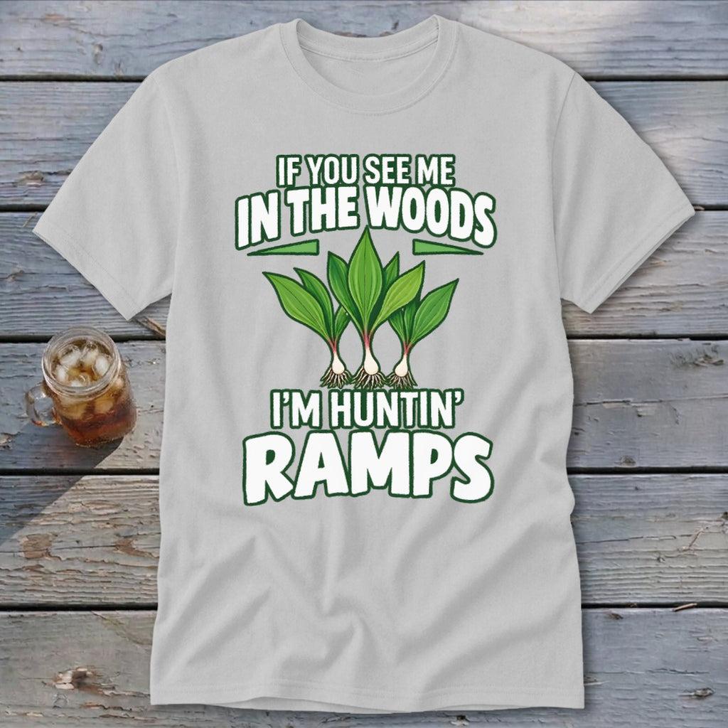 A light gray t-shirt with green text reading "IF YOU SEE ME IN THE WOODS I'M HUNTIN' RAMPS" and an illustration of three ramp plants.