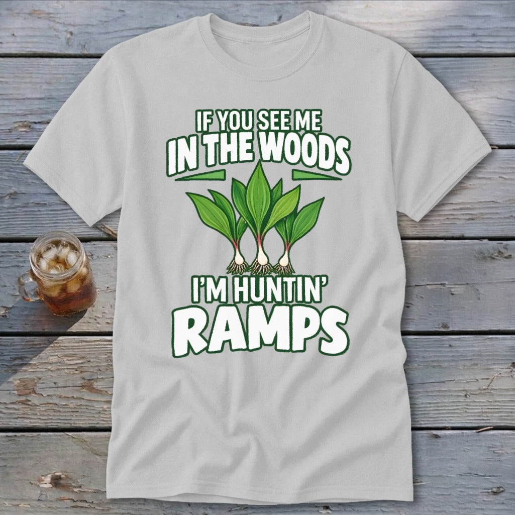 A light gray t-shirt with green text reading "IF YOU SEE ME IN THE WOODS I'M HUNTIN' RAMPS" and an illustration of three ramp plants.
