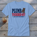 Light blue t-shirt with "PLUMB TUCKERED OUT AND IT AIN'T EVEN DINNER" text and rocking chair graphic.