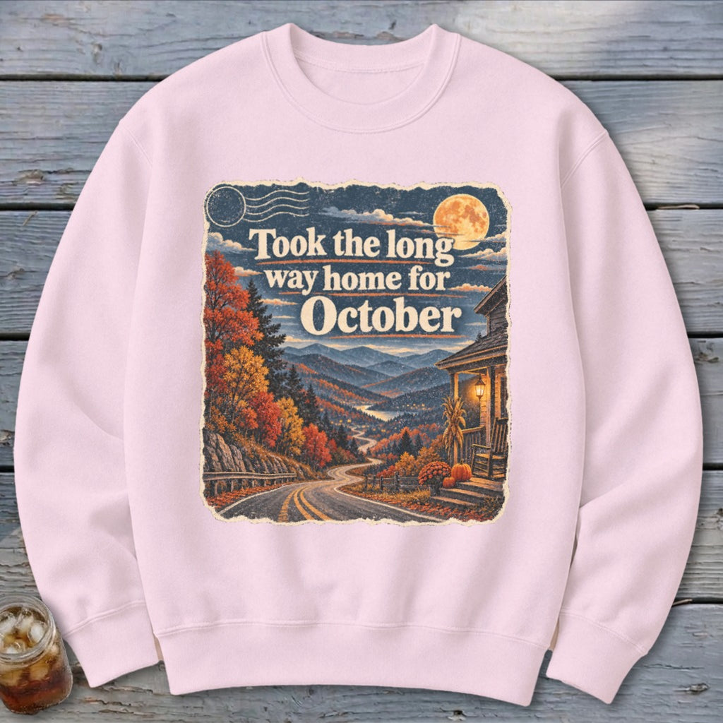 Pink sweatshirt with "Took the long way home for October" text and autumn mountain landscape.