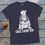 Navy t-shirt with white graphic of a boy in overalls and cap holding a bucket, text reads "COAL CAMP KID".