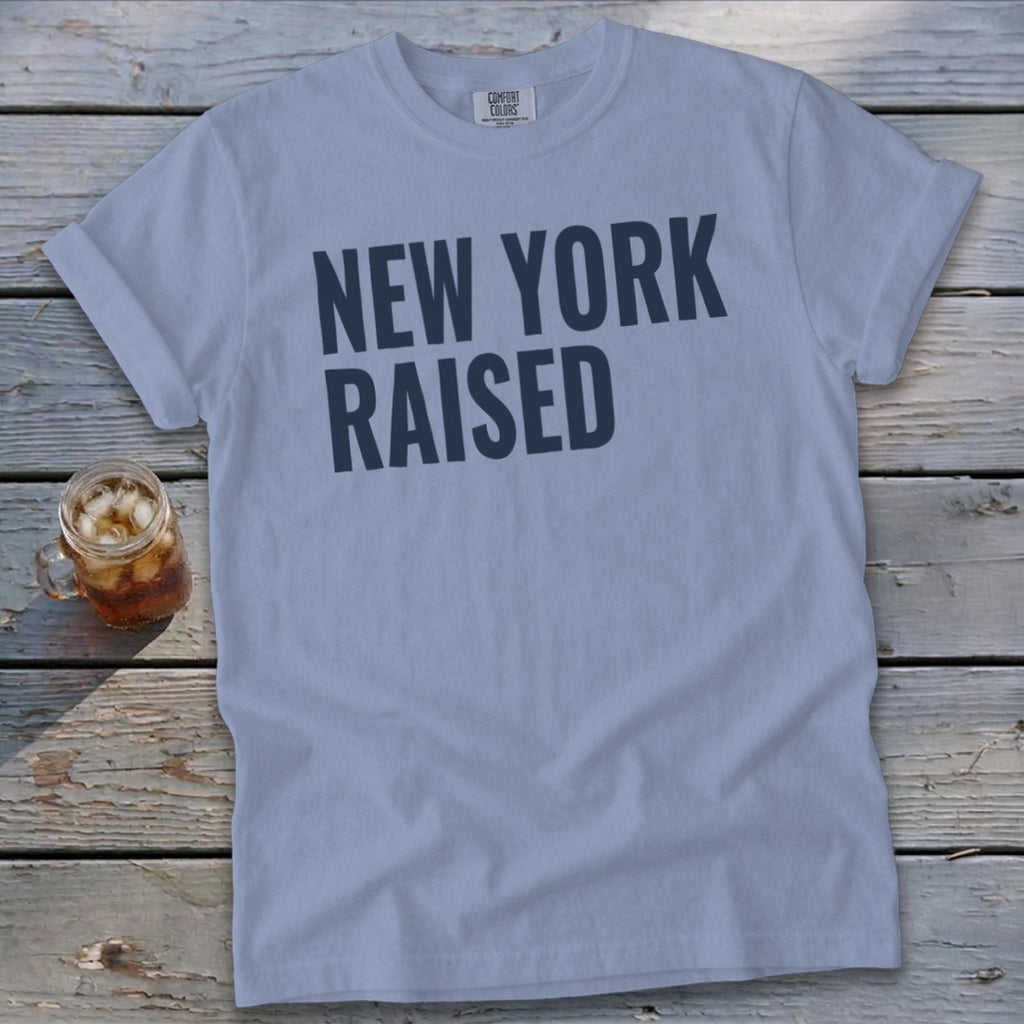Light blue t-shirt with "NEW YORK RAISED" text and a glass of iced tea.
