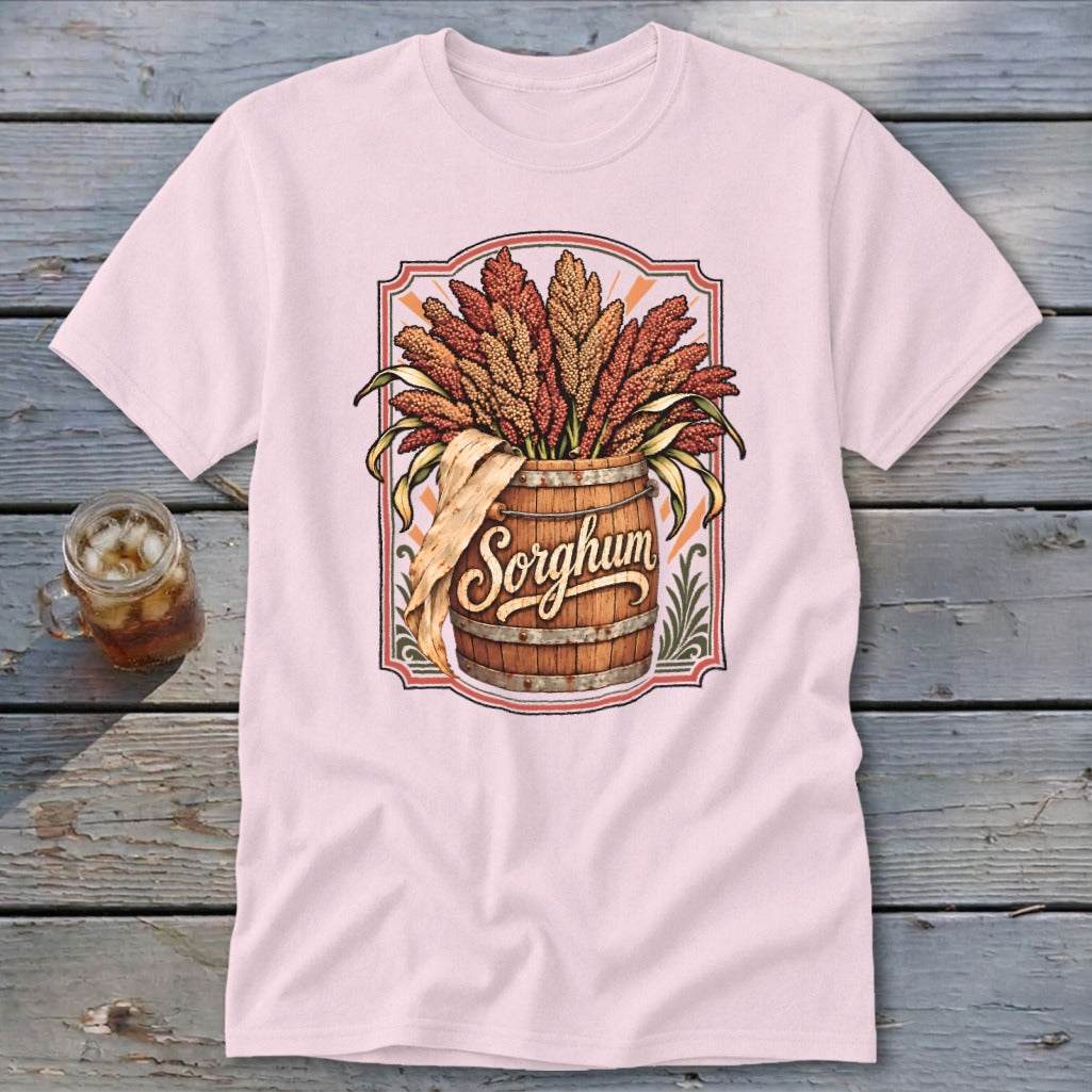 Pink t-shirt featuring a wooden barrel overflowing with sorghum stalks, with the word "Sorghum" in script.