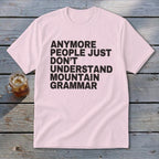 Pink t-shirt with black text that reads "anymore people just don't understand mountain grammar".