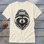 Cream t-shirt with a black and white illustration of a raccoon wearing a beanie with mountains.