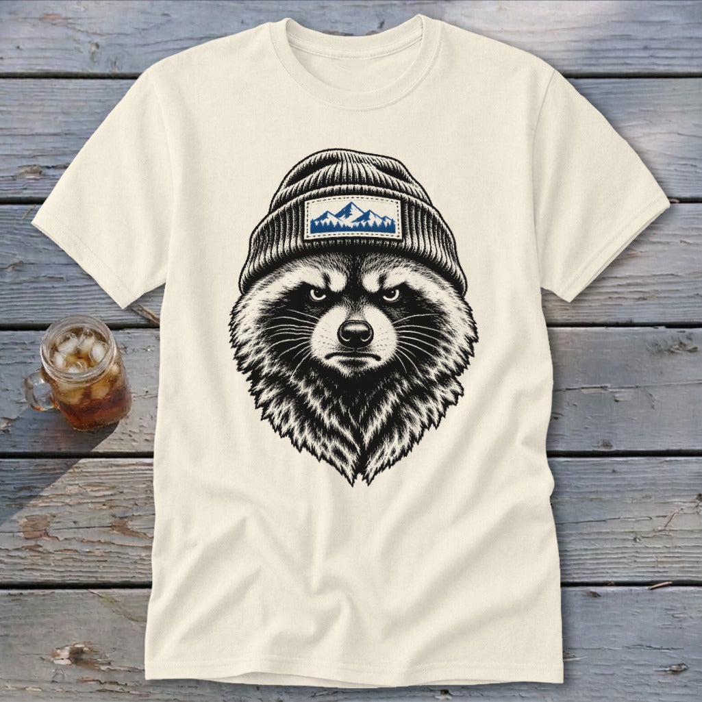 Cream t-shirt with a black and white illustration of a raccoon wearing a beanie with mountains.