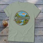 Light green t-shirt with a circular graphic of a scenic landscape and the word "Mississippi".