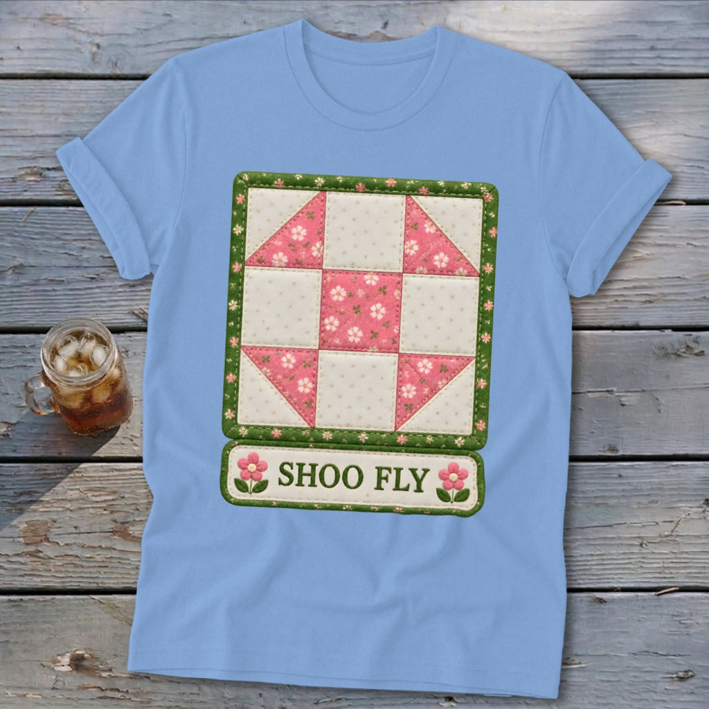 Light blue t-shirt featuring a "Shoo Fly" quilt block design with pink floral accents.