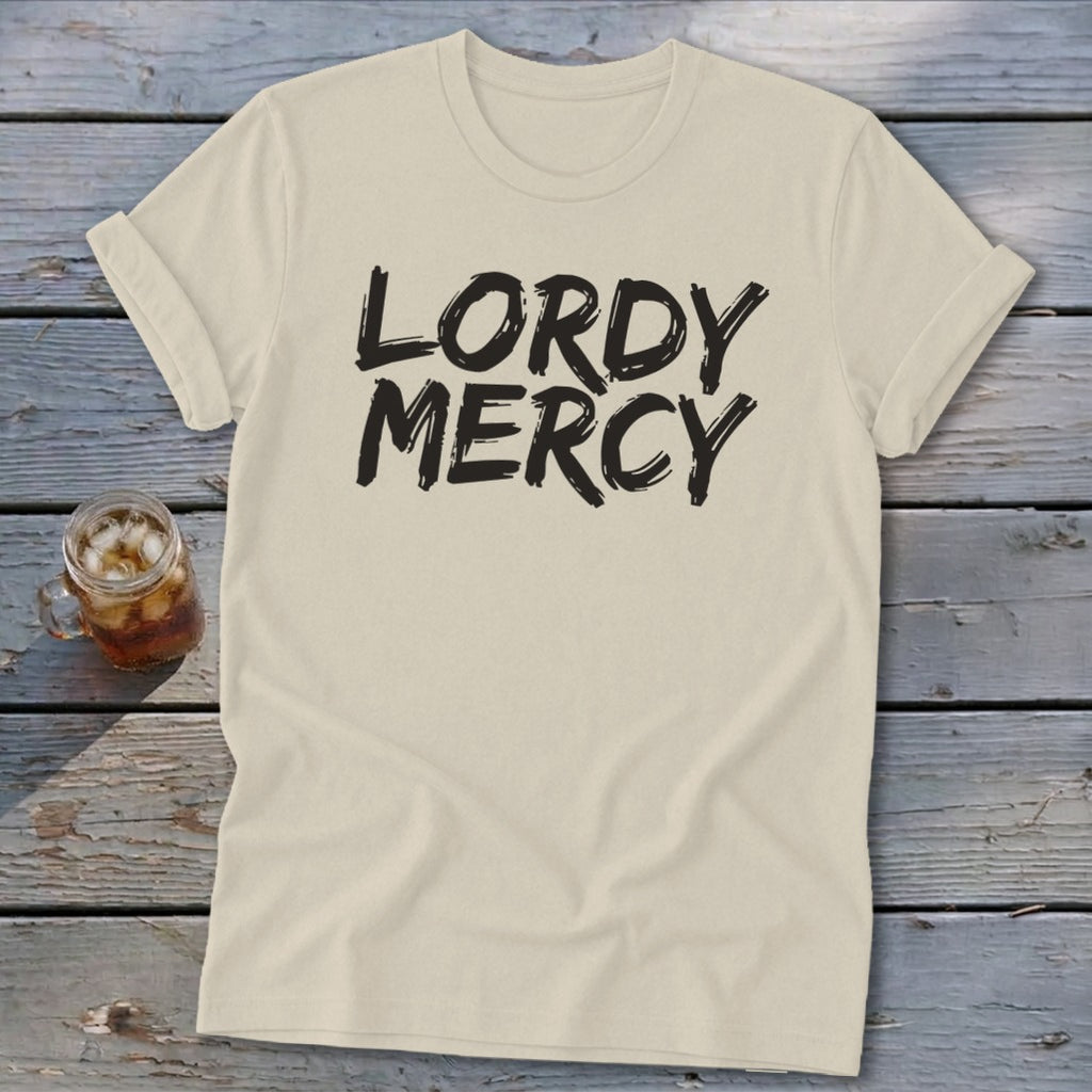 Cream t-shirt with black text reading "LORDY MERCY" and a glass of iced tea.
