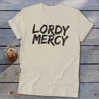 Cream t-shirt with black text reading "LORDY MERCY" and a glass of iced tea.