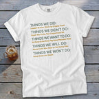 White t-shirt with "Things We Did" and other lists printed in green and gold.