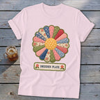 Pink t-shirt with a colorful Dresden Plate quilt block graphic and text.