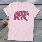 Light pink t-shirt featuring a maroon bear graphic containing the text Appalachia, laid on weathered wood.