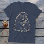 T-shirt graphic of a bear carving wood with a knife.