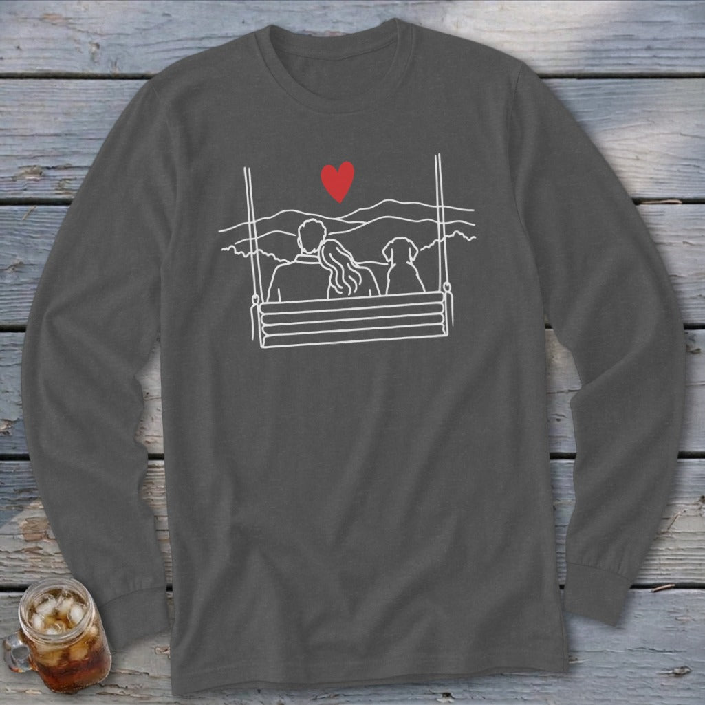 Line art of couple and dog on swing with heart and mountains above.