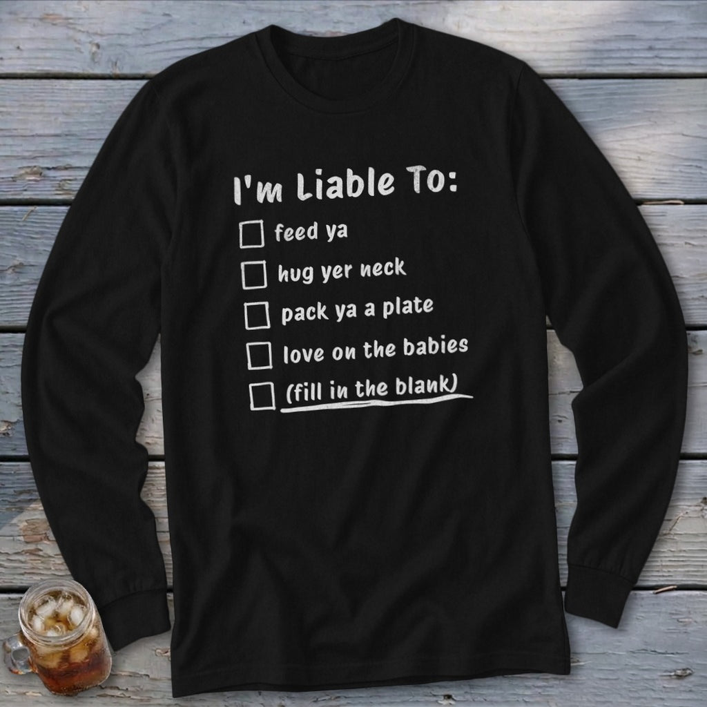Black long-sleeve shirt with checklist text "I'm Liable To: feed ya, hug yer neck, pack ya a plate, love on the babies, (fill in the blank)".