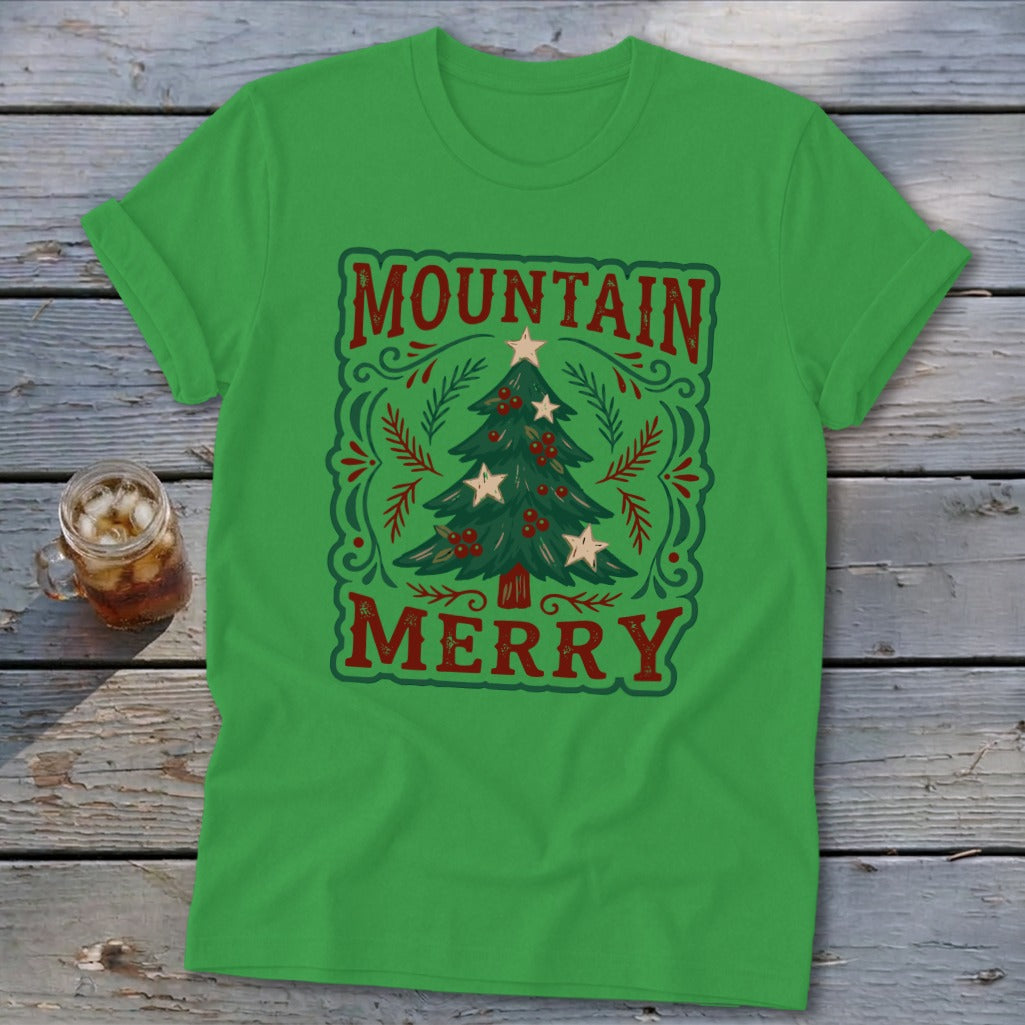 Bright green t-shirt with a vintage Christmas tree graphic and the text Mountain Merry on a rustic wooden background.
